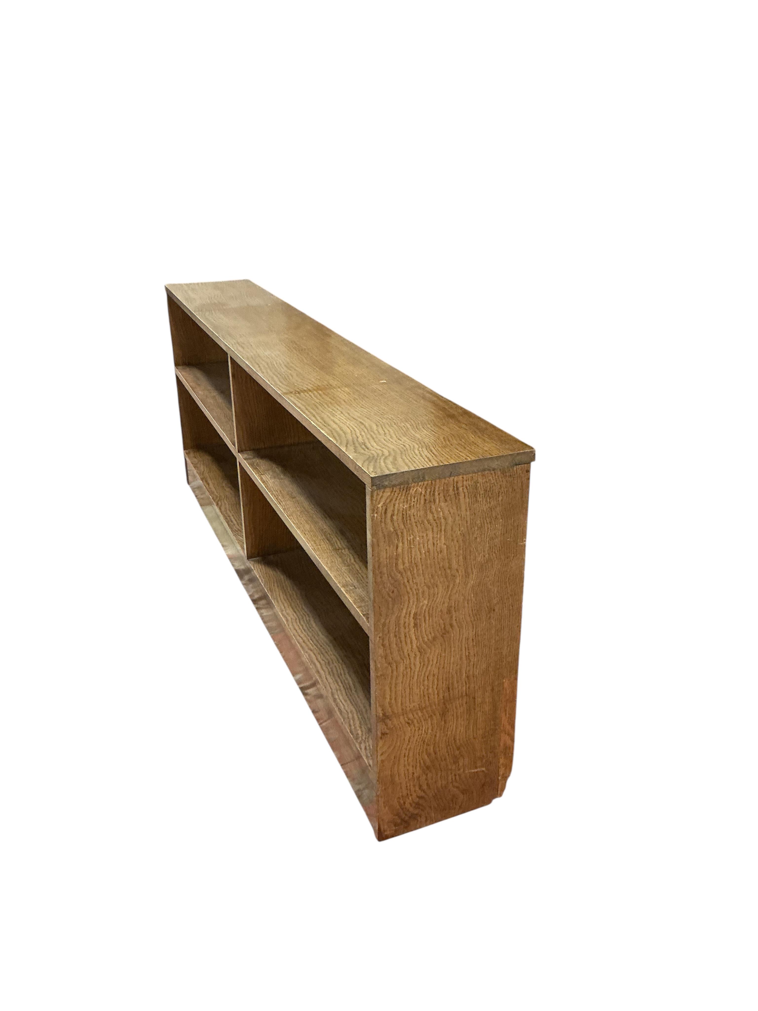 A mid century oak dwarf open bookcase, width 176cm, depth 27cm, height 67cm